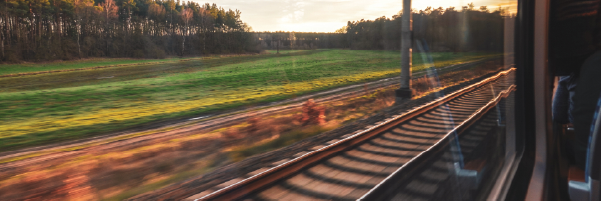 A picture containing a view of train tracks out of a train window