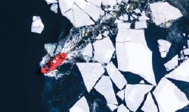 A 
                           picture containing a red ice breaker ship ploughing through an ice field