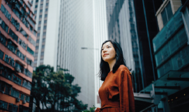 A picture containing a woman in a city with 
high rise buildings