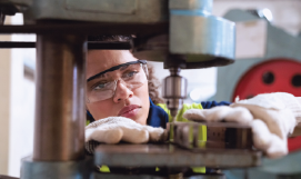 A 
picture containing a female working a drill at a plant